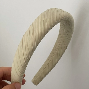 Détail du tissu plissé beige sur un serre-tête rembourré épais pour femmes et filles