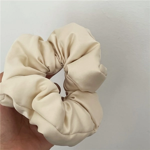 Dettaglio dell'elastico in raso crema che mostra la trama lucida e il volume soffice