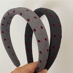 Close-up of thick sponge headbands in grey and black featuring red heart patterns