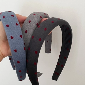 Detail of three thick padded headbands with red heart patterns in blue and grey shades