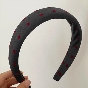 Detail of sponge padded black headband featuring vibrant red heart patterns