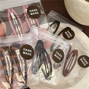 Close-up of assorted vintage leopard and colorful drop oil hair clips in handmade packaging