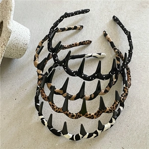 Detailed top view of leopard print and polka dot fabric headbands with punk spikes