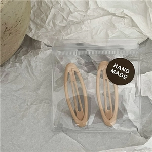 Neutral beige matte hair clips set in handmade packaging on decorative ceramic plate