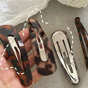 Detailed view of leopard print water-drop hair clips with secure silver metal snap backing