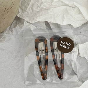 Detail of tortoise shell water-drop hair clips with hand-made label in packaging