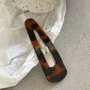 Detail view of leopard print hair clip with high-gloss finish and metal spring clip