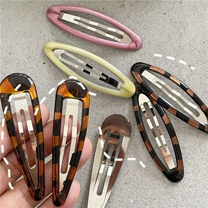 Detail of leopard print and solid color resin BB hair clips in various oval shapes