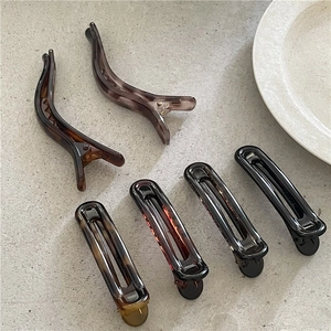 Detail of six leopard and amber resin hair clips with elegant geometric line designs