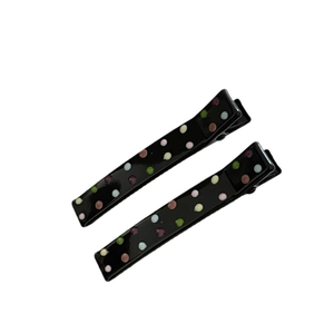 Pair of black polka dot duckbill hair clips with colorful resin dots on white background