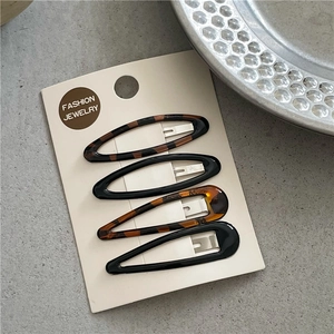 Close-up of leopard print and glossy black BB hair clips set on a display card