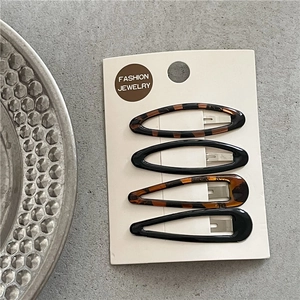 Detail view of leopard print and solid black BB clips on a white display card