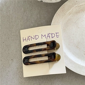 Macro shot of two leopard print duckbill hair clips on handmade card display