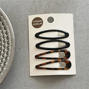 Detail of four-piece leopard print and black resin hair clips on a display card
