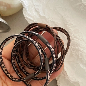 Close-up of leopard print and dark brown elastic hair ties with cylindrical buckles