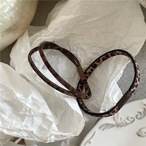 Detailed macro view of leopard print elastic hair bands on a white decorative plate