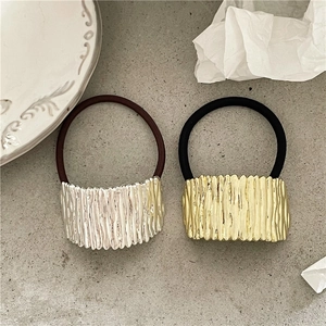 Detail of vintage gold and silver alloy ponytail holders with vertical pleated metal texture