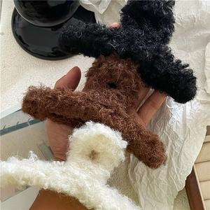 Detaillierte Makroaufnahme von Plüsch-Haarklammern in Schwarz, Braun und Creme für das Haarstyling