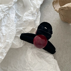 Close-up of velvet flocked mini hair claw clip with a large glossy dark red pearl bead