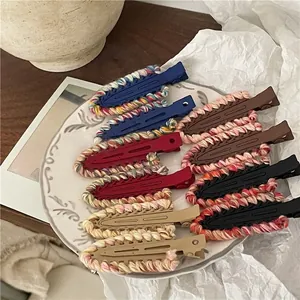 Colorful knitted wool drop-shaped hair clips in retro colors on a white ceramic plate