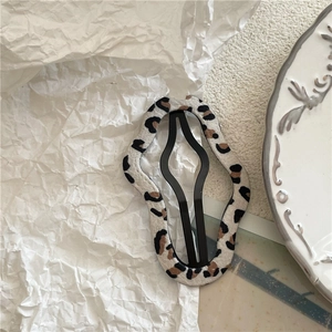 Close-up of leopard print hair clip with wavy fabric edges and black metal BB snap clip