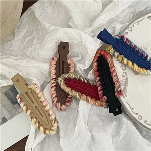 Close-up of colorful hand-woven yarn hair clips in various vibrant knitted patterns