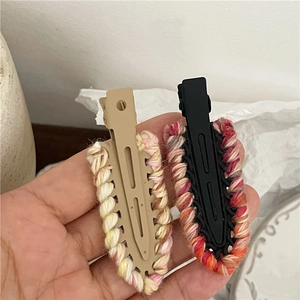 Close-up of handmade colorful wool yarn crochet trim on matte hair duckbill clips
