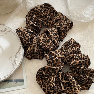 Pair of leopard print scrunchies in glossy fabric for stylish hair accessories