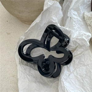 Dettaglio della pinza per capelli a farfalla nera lucida con finitura a specchio e molla