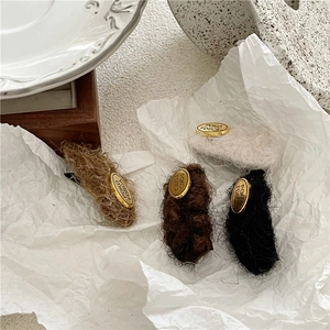 Close-up of plush velvet geometric hair clips with gold metal tag in autumn earth tones
