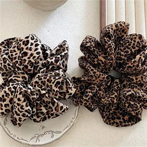 Chic oversized leopard print hair scrunchies set on a white vintage plate for women