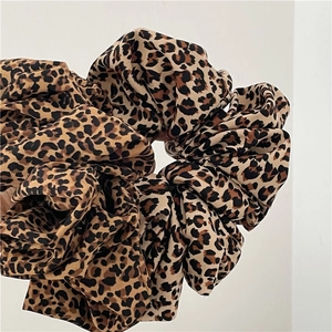 Detailed view of large leopard print scrunchie showing soft fabric texture and patterns