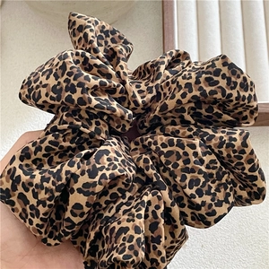 Detail shot of large leopard print scrunchie showing soft fabric texture and pleated design