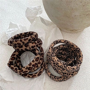Close-up of leopard print scrunchies set featuring soft velvet texture on white paper