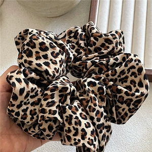 Detail showing the large leopard print scrunchie made of smooth satin-like fabric