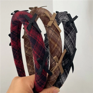 Detail of plaid padded headbands with cute bows in red, brown and grey tweed fabric