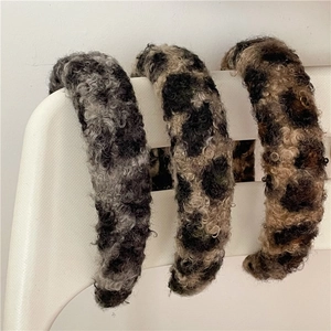 Vue détaillée de trois bandeaux en peluche léopard épais en tons gris, beige et marron
