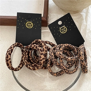 Close-up of leopard print hair ties set on handmade display cards with textured background