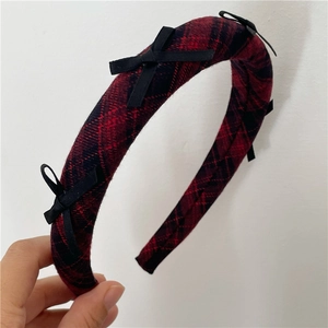Detailed view of red black checkered headband with elegant small black bows decoration
