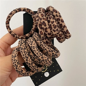 Close-up of elastic hair ties with leopard print patterns on a black display card