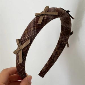 Close-up of padded plaid headband with small bow details and brown checkered fabric
