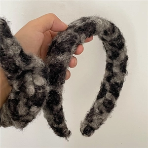 Gros plan sur la texture épaisse en laine d'agneau du serre-tête en peluche léopard