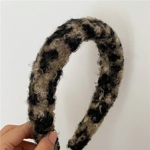 Vue détaillée du serre-tête en peluche à motif léopard avec une texture bouclée