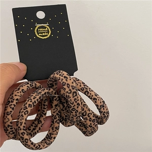 Detail of leopard print scrunchies set on handmade display card with soft texture