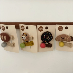 Detail view of handmade felt hair clips featuring cute cartoon bread and cookie designs