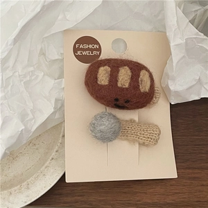 Detailed macro view of wool felt bread and cookie hair clips on display card