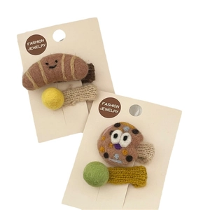 Handmade felt hair clips featuring croissant and cookie designs with cute wool balls