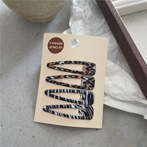 Détail de quatre barrettes BB à motifs léopard et zèbre sur carte de présentation
