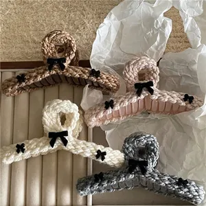 Knitted hair claw clips in four colors with black velvet bows on velvet tray