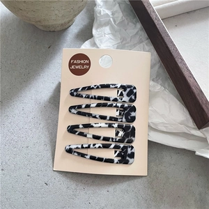 Détail d'un lot de 4 pinces à cheveux à motif marbre noir et blanc sur emballage